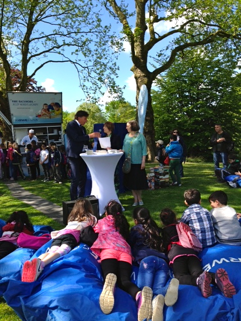 Grugapark am 13. Mai 2015: Vor der Einweihung des (noch verhüllten) offenen RWE-Bücherschranks, der dritte in Essen. Kinder stehen am RWE-Backmobil nach Waffeln an und freuen sich auf die Lesung aus EINE TÜTE GRÜNER WIND von Gesine Schulz.